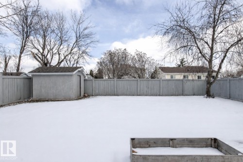 The property features a large, enclosed backyard with a storage shed, a raised garden bed, and mature trees - 3668 31A Street, Edmonton, AB - Outdoor