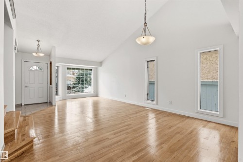 This spacious room features vaulted ceilings, hardwood floors, and large windows that provide ample natural light - 3668 31A Street, Edmonton, AB - Indoor Photo Showing Living Room