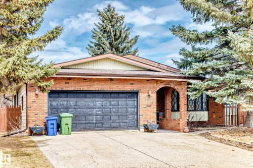 Brick exterior with an arched entryway, double garage door, and a prominent front-facing gable - 208 Willow Crescent, Wetaskiwin, AB - Outdoor