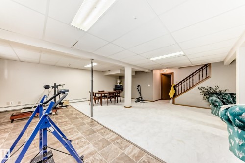 Versatile lower-level space featuring a drop ceiling with integrated lighting - 208 Willow Crescent, Wetaskiwin, AB - Indoor