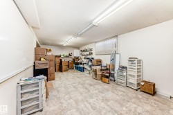 Spacious room featuring tile-finish flooring, white walls, and overhead fluorescent lighting - 
