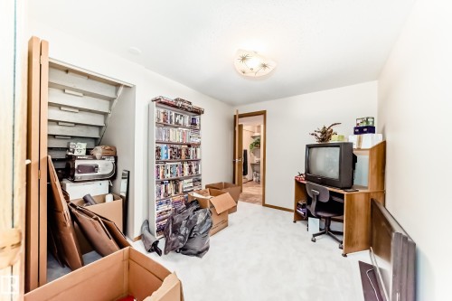 Carpeted room featuring a ceiling-mounted light fixture, light-colored walls, and wood-finish trim - 208 Willow Crescent, Wetaskiwin, AB - Indoor
