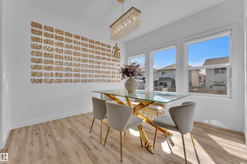 The dining area features light-toned flooring, white walls, and a contemporary light fixture - 7815 174 Avenue, Edmonton, AB - Indoor Photo Showing Dining Room