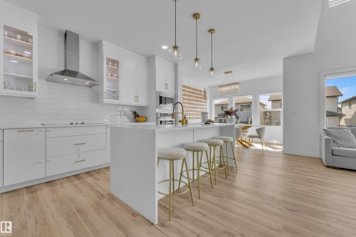 This bright open-concept living space features light-toned flooring, white walls, and abundant natural light from several windows - 7815 174 Avenue, Edmonton, AB - Indoor Photo Showing Kitchen