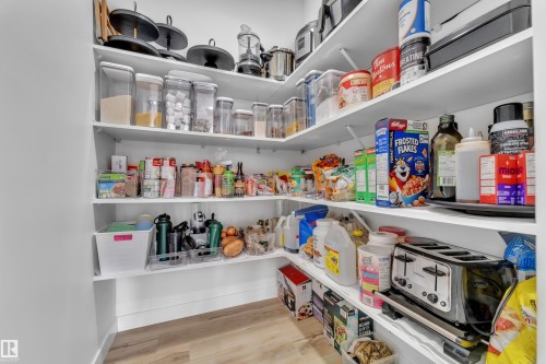 The pantry features extensive white shelving, providing ample storage space - 7815 174 Avenue, Edmonton, AB - Indoor With Storage