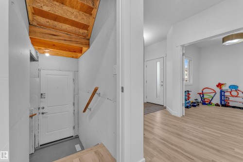 This property features light-colored flooring in the main area, white walls, and a front entry door with a frosted glass panel - 7815 174 Avenue, Edmonton, AB - Indoor Photo Showing Other Room