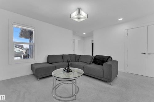 This living area features a clean, neutral color palette with light-colored carpeting and white walls - 7815 174 Avenue, Edmonton, AB - Indoor Photo Showing Living Room