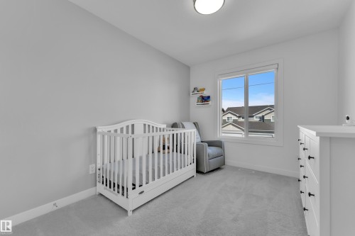This room features a window providing natural light, light gray carpeting, and light colored walls - 7815 174 Avenue, Edmonton, AB - Indoor Photo Showing Bedroom