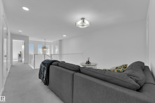 The property features a spacious loft area with recessed lighting, white walls, and light-colored carpeting - 7815 174 Avenue, Edmonton, AB - Indoor