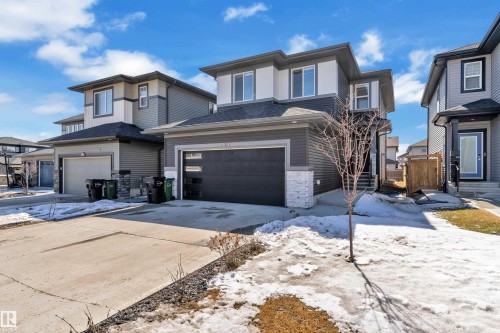 The property features a contemporary exterior with multi-toned siding, a two-car garage with frosted glass panels, and a concrete driveway - 7815 174 Avenue, Edmonton, AB - Outdoor With Facade