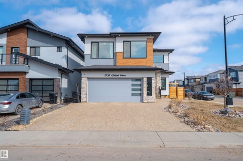 The property features a contemporary exterior with a light-colored facade, dark trim, and wood-look accents - 3130 Kostash Green, Edmonton, AB - Outdoor
