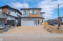 The property features a contemporary exterior with a light-colored facade, dark trim, and wood-look accents - 3130 Kostash Green, Edmonton, AB  - Outdoor 