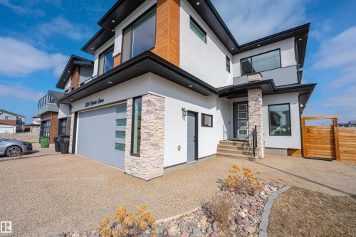 The property features a modern exterior with a light-colored stucco finish and wood accents - 3130 Kostash Green, Edmonton, AB - Outdoor