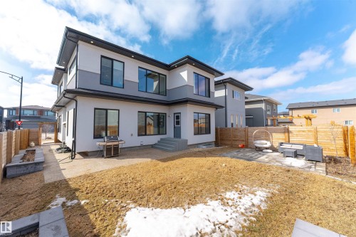 The property features a modern exterior with a light-colored stucco finish, dark trim, and large windows - 3130 Kostash Green, Edmonton, AB - Outdoor