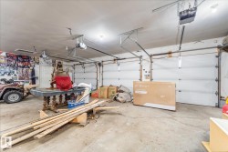 Spacious two-car garage with concrete flooring and multiple overhead light fixtures - 