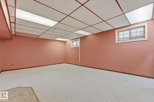 Spacious room featuring light-colored carpet, a drop ceiling with integrated lighting, and two windows - 25750 18 Street, Edmonton, AB - Indoor Photo Showing Other Room