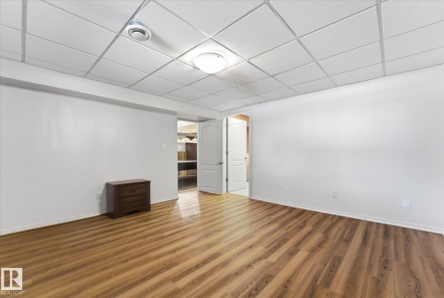 Open room featuring wood-finish flooring and a white drop ceiling - 25750 18 Street, Edmonton, AB - Indoor Photo Showing Other Room