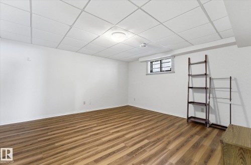 Spacious room featuring wood-finish flooring, white walls, and a dropped ceiling with recessed lighting - 25750 18 Street, Edmonton, AB - Indoor Photo Showing Other Room