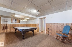 Recreation room featuring paneled walls, carpet flooring, drop ceiling, recessed lighting, and an open doorway to another room - 
