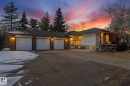 Residence exterior featuring a three-car garage, brick accents, and a multi-level deck - 25750 18 Street, Edmonton, AB  - Outdoor 