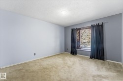 Room featuring wall-to-wall carpeting, light blue wall paint, a window with a sill, and an overhead flush-mount light fixture - 