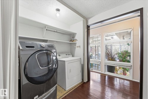 Dedicated laundry area featuring built-in shelving, overhead lighting, and wood-finish flooring - 25750 18 Street, Edmonton, AB - Indoor Photo Showing Laundry Room