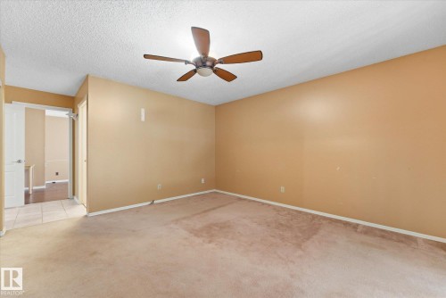 Spacious room featuring neutral-toned walls, a textured ceiling, and a ceiling fan with wood-finish blades - 25750 18 Street, Edmonton, AB - Indoor Photo Showing Other Room