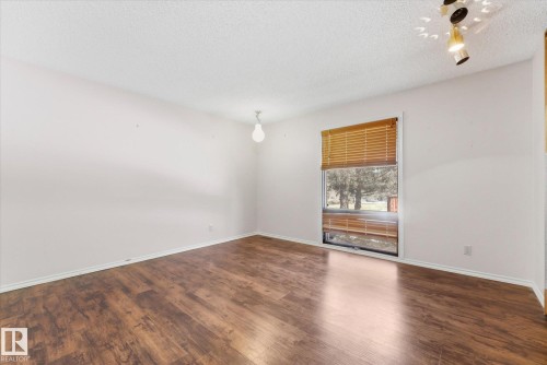 Room featuring wood-finish flooring, white walls, and a window with wood blinds - 25750 18 Street, Edmonton, AB - Indoor Photo Showing Other Room