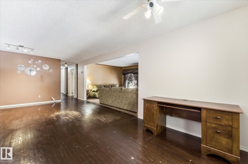 Expansive room with dark wood-finish flooring, a neutral wall color, and a ceiling fan with integrated lighting - 25750 18 Street, Edmonton, AB - Indoor Photo Showing Other Room