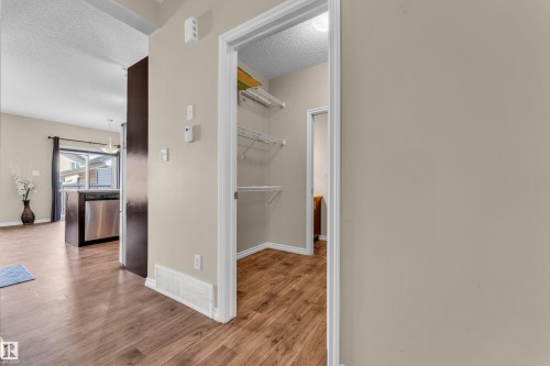 Interior hallway featuring wood-finish flooring, light neutral paint, and white baseboards - 2526 19A Avenue, Edmonton, AB - Indoor