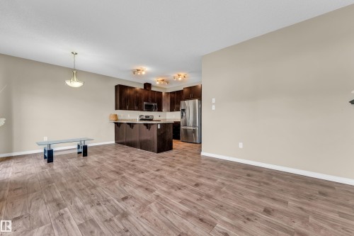 Spacious living area featuring wood-finish flooring and neutral wall tones - 2526 19A Avenue, Edmonton, AB - Indoor Photo Showing Kitchen