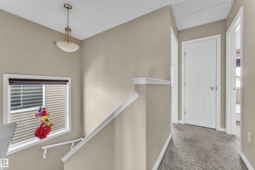 Carpeted hallway with a white panel door and recessed overhead lighting - 2526 19A Avenue, Edmonton, AB - Indoor Photo Showing Other Room