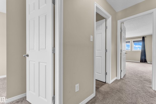 Hallway featuring neutral-toned walls, white trim, and textured carpeting - 2526 19A Avenue, Edmonton, AB - Indoor Photo Showing Other Room
