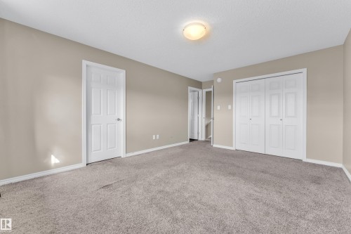 Spacious room featuring neutral carpeting, light beige wall paint, and white trim - 2526 19A Avenue, Edmonton, AB - Indoor