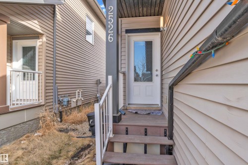 Front entry featuring a white door with upper glass panel, wood-finish steps, and a white railing - 2526 19A Avenue, Edmonton, AB - Outdoor With Exterior