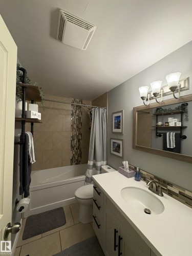 Bathroom featuring a white vanity with a rectangular undermount sink, a coordinating white countertop, and dark hardware - 79 Akinsdale Gardens, St. Albert, AB - Indoor Photo Showing Bathroom