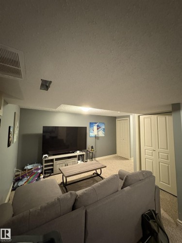 Carpeted room with light gray walls, featuring two paneled doors and recessed ceiling lighting - 79 Akinsdale Gardens, St. Albert, AB - Indoor