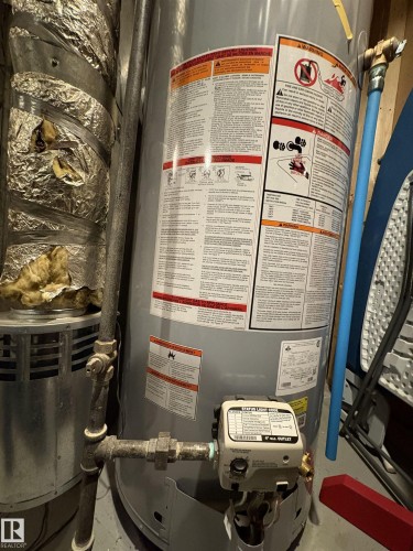 Water heater unit with visible control panel and connected plumbing lines - 79 Akinsdale Gardens, St. Albert, AB - Indoor Photo Showing Basement