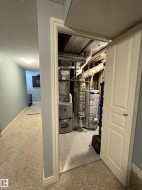 Utility room featuring a water heater, furnace, and exposed ductwork - 
