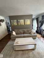 Living area featuring wood-finish flooring and a textured area rug - 