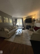 Living area with wood-finish flooring and a central area rug - 
