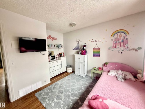 Hardwood-finish flooring complements white walls and trim, providing a neutral canvas - 3520 17B Avenue, Edmonton, AB - Indoor Photo Showing Bedroom