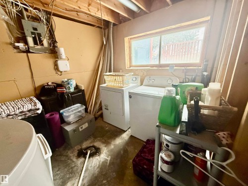 Utility area featuring exposed ceiling joists, a service panel, and a rectangular window - 3520 17B Avenue, Edmonton, AB - Indoor Photo Showing Laundry Room