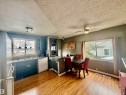 Open-concept kitchen and dining area featuring wood-finish flooring, dark cabinetry, and a tile backsplash - 3520 17B Avenue, Edmonton, AB  - Indoor Photo Showing Dining Room 