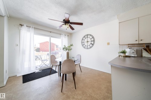 Open-concept dining area with tiled flooring, a ceiling fan, and sliding glass doors leading to an exterior patio - 3518 78 Street, Edmonton, AB - Indoor Photo Showing Dining Room