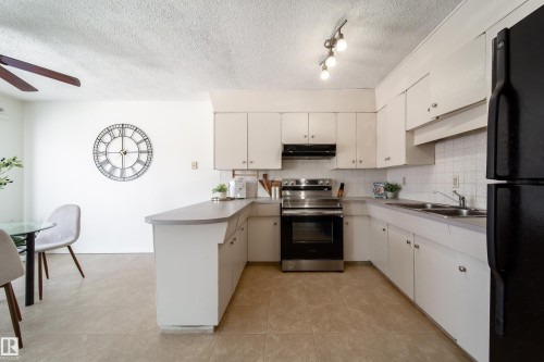 Kitchen featuring white cabinetry, a stainless steel range, and a dual-basin sink - 3518 78 Street, Edmonton, AB - Indoor Photo Showing Kitchen With Double Sink