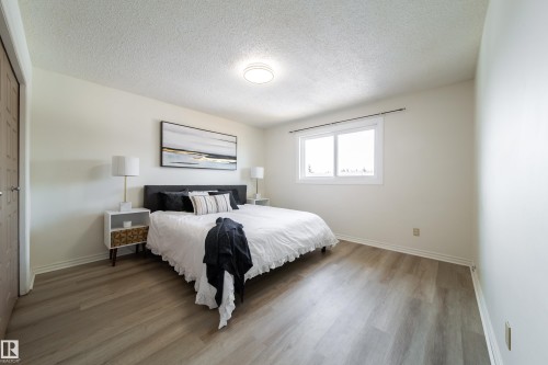 This bright room features light-colored walls, a ceiling light fixture, and a window providing natural light - 3518 78 Street, Edmonton, AB - Indoor Photo Showing Bedroom