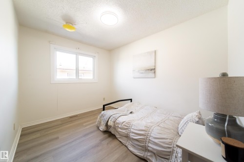 This room features a window providing natural light, light-colored walls, and wood-style flooring - 3518 78 Street, Edmonton, AB - Indoor Photo Showing Bedroom