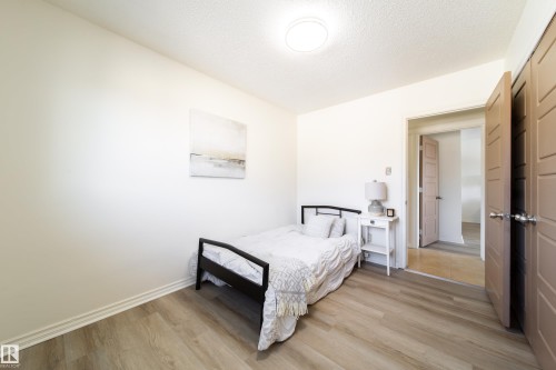 The room features light-colored walls and wood-style flooring, creating a bright and inviting atmosphere - 3518 78 Street, Edmonton, AB - Indoor Photo Showing Bedroom