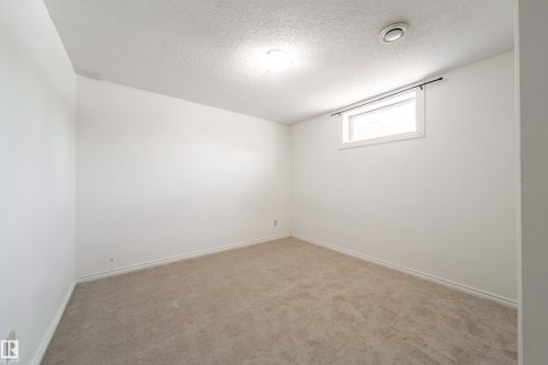 This interior room features light-colored carpeting, white walls, and a window providing natural light - 3518 78 Street, Edmonton, AB - Indoor Photo Showing Other Room